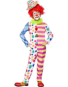 Simpatico pagliaccio per bambini in costume e parrucca da clown  celebrazione del giorno dello sciocco di aprile bambina in un divertente  travestimento su sfondo grigio