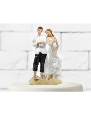 Figur kue pengantin dengan pengantin di pasir