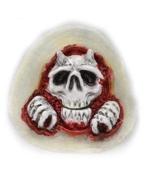 Prothèse tête de mort sortant de la peau